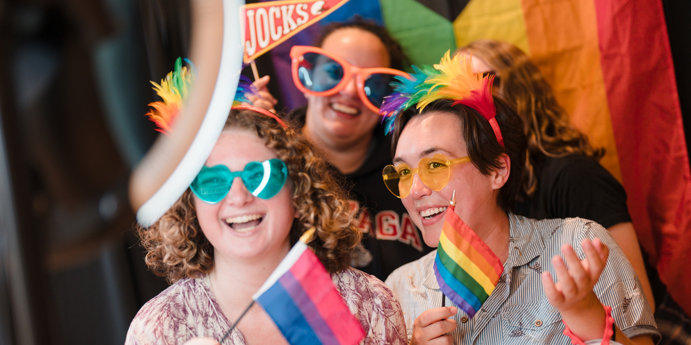 Students with pride flags taking pictures with a digital photobooth